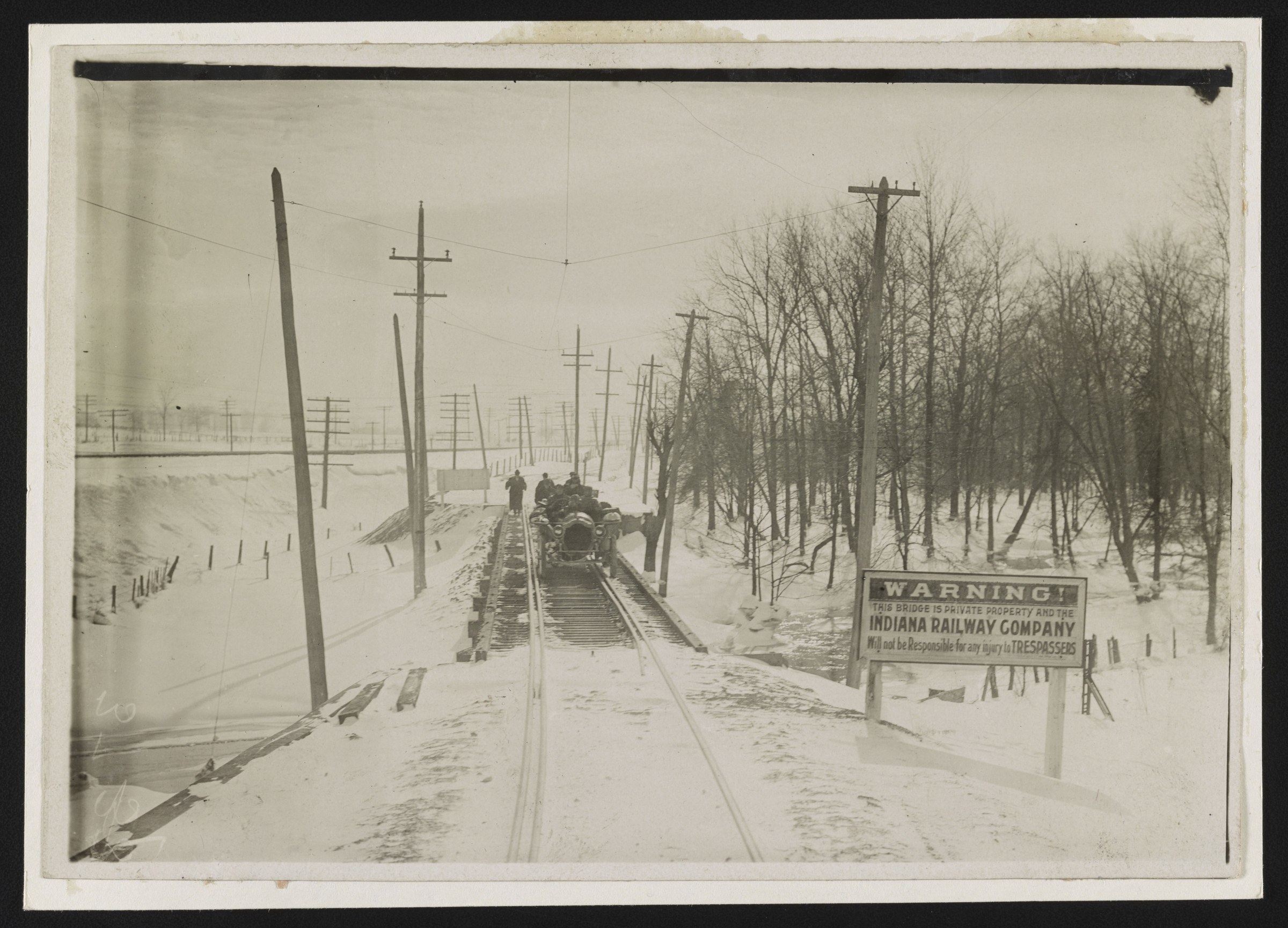 The Thomas Flyer on the rails crossing a snowy Indiana railroad bridge during the 1908 New York to Paris race