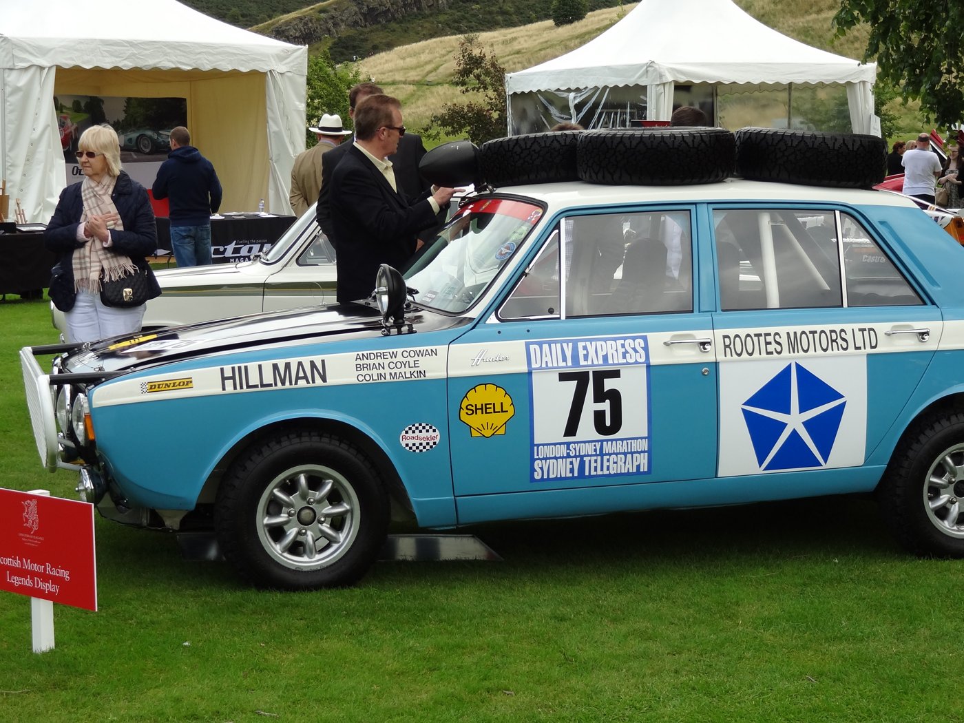 Blue No. 75 Hillman Hunter in 1968 London to Sydney Marathon livery on display on a grass showground