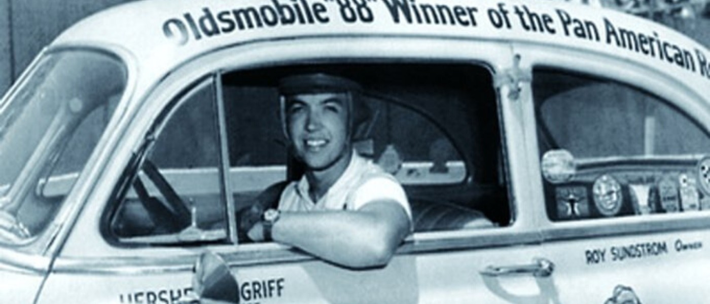 Hershel McGriff smiling from the window of his white 1950 Oldsmobile 88, roof lettered as Pan American race winner