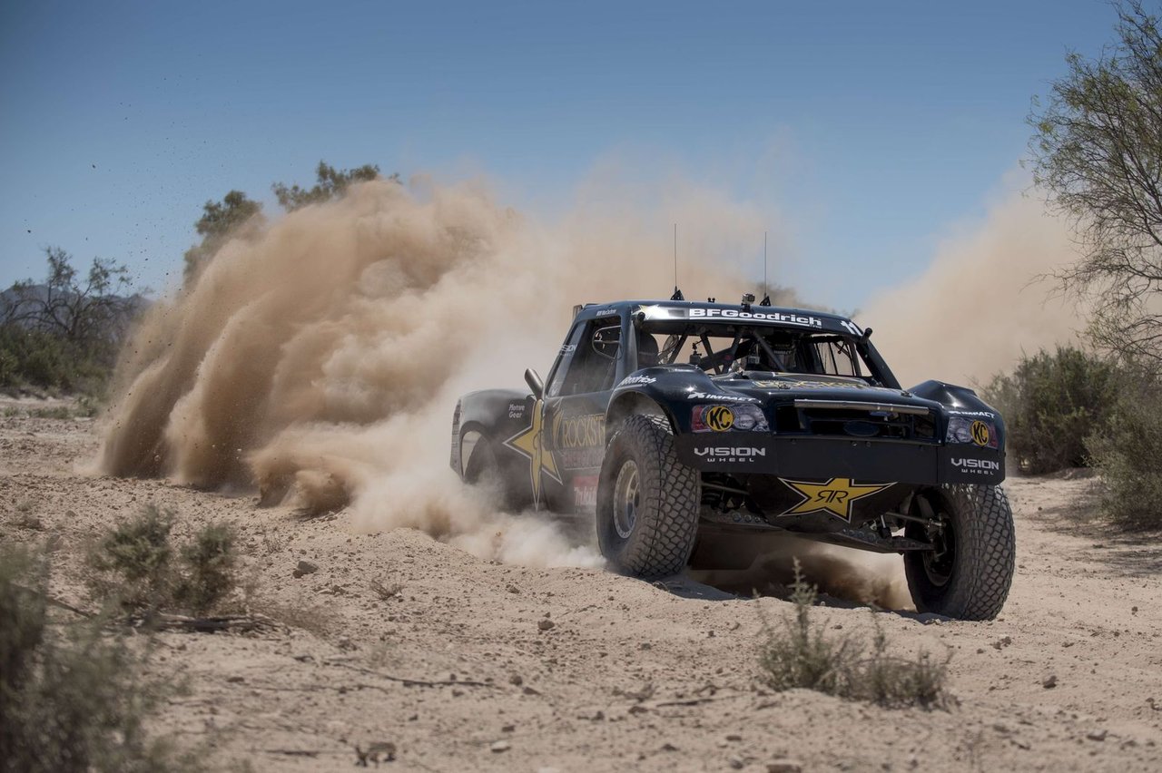 A Rockstar BFGoodrich Trophy Truck kicking up a wall of dust on a desert course