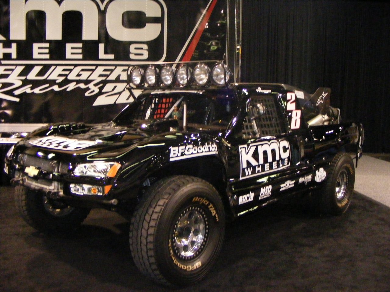 A white Trophy Truck racing across open desert